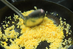 大火加熱炒鍋，再入油，燒到四至五成熱時倒入雞蛋液，在未凝結(jié)之前，加米飯煸炒，不停翻炒并用鍋鏟將成塊的米飯碾開、撥散。