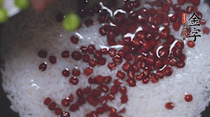 將炒好的食材和大米、紅豆一起放進(jìn)電飯鍋煮。