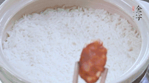 煮開(kāi)后轉(zhuǎn)小火，當(dāng)米飯出現(xiàn)小孔時(shí)，鋪上金字麻辣香腸。