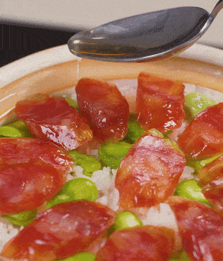 大米出現(xiàn)小孔時(shí)開蓋放香腸，往鍋邊淋入少許油，再燜煮8~10分鐘左右。