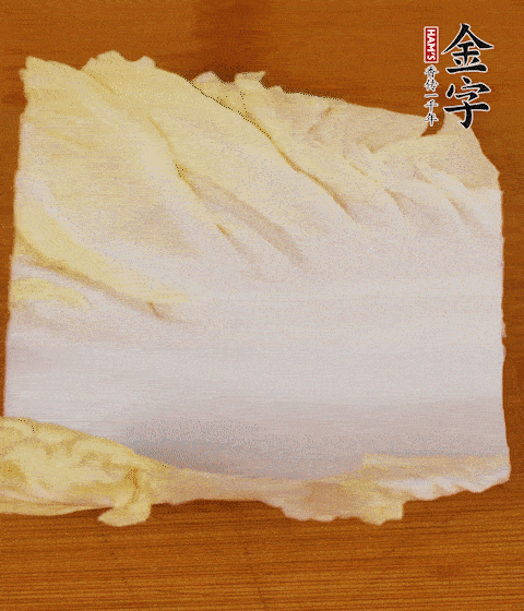 一片白菜一片淡火腿交替疊起，疊個兩三層放進鍋內(nèi)，直到塞滿鍋。