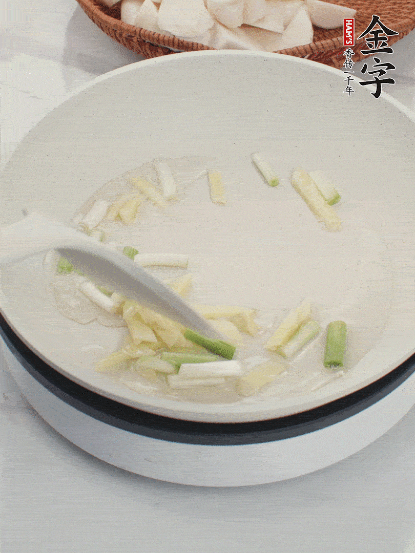 鍋中油五成熱，下蔥白、姜片爆香。