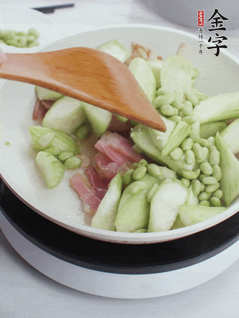 依次下絲瓜、青豆翻炒，炒至絲瓜打蔫縮小。