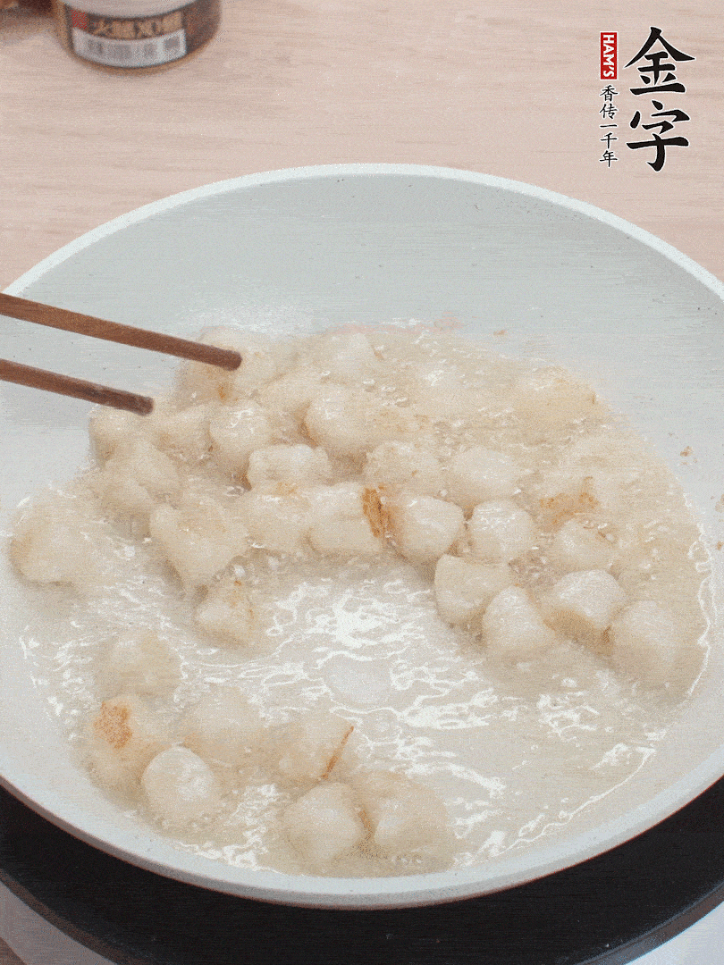 油溫4成熱，鮮貝蘸干淀粉下鍋煎，一面微黃后翻面。