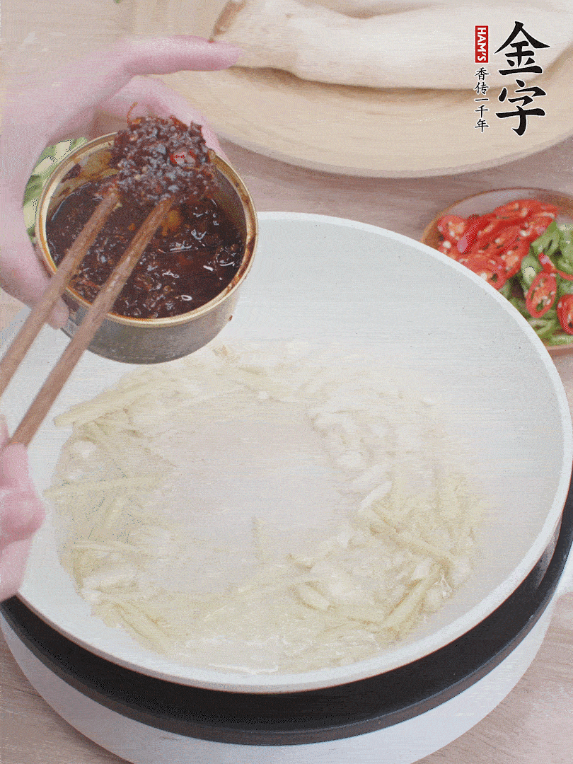 起鍋熱油，姜蒜、金字火腿干貝醬煸香。