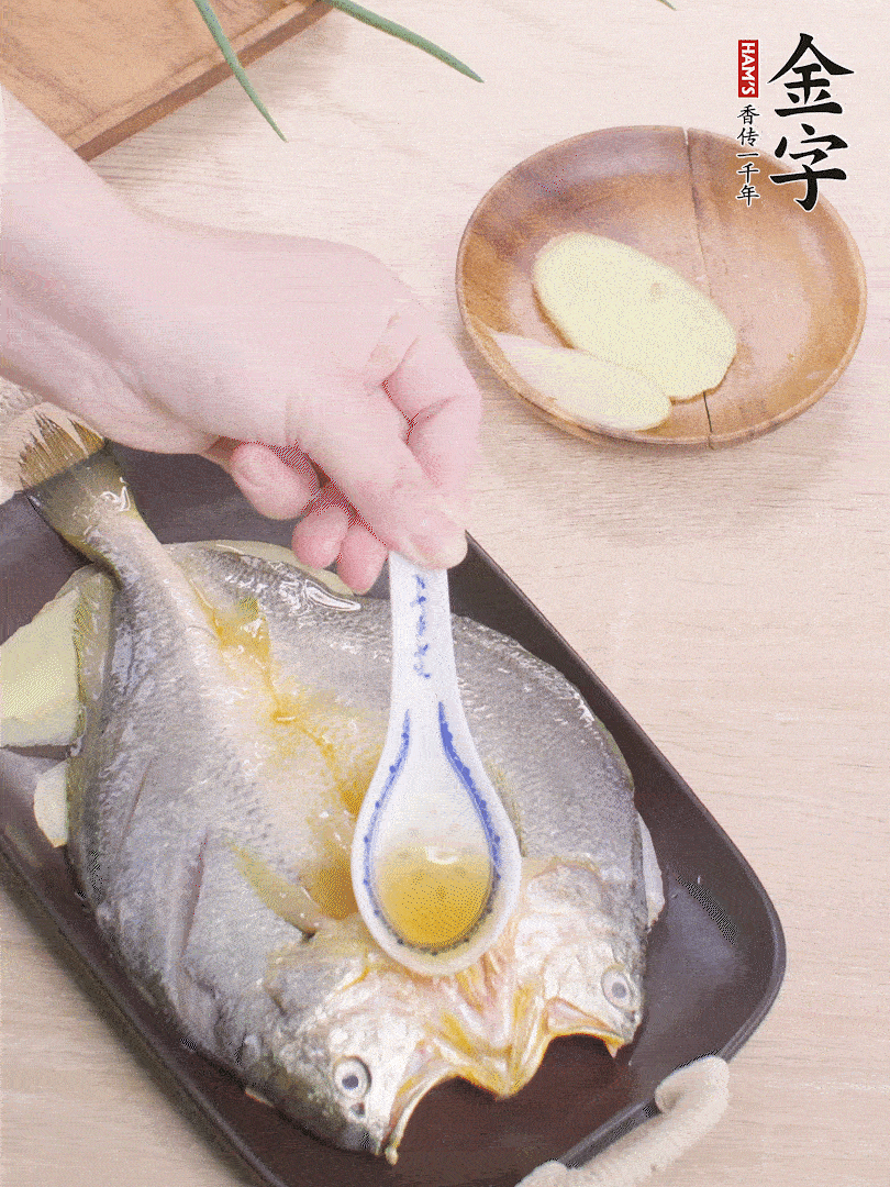 盤(pán)底鋪姜片，放黃魚(yú)，淋2勺料酒。