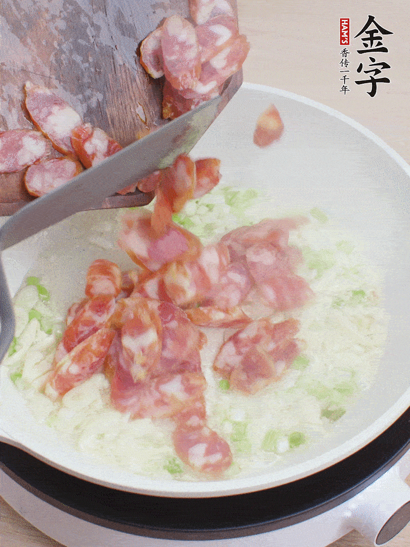 油5成熱，蒜末、蔥白爆香，下香腸炒出香味。