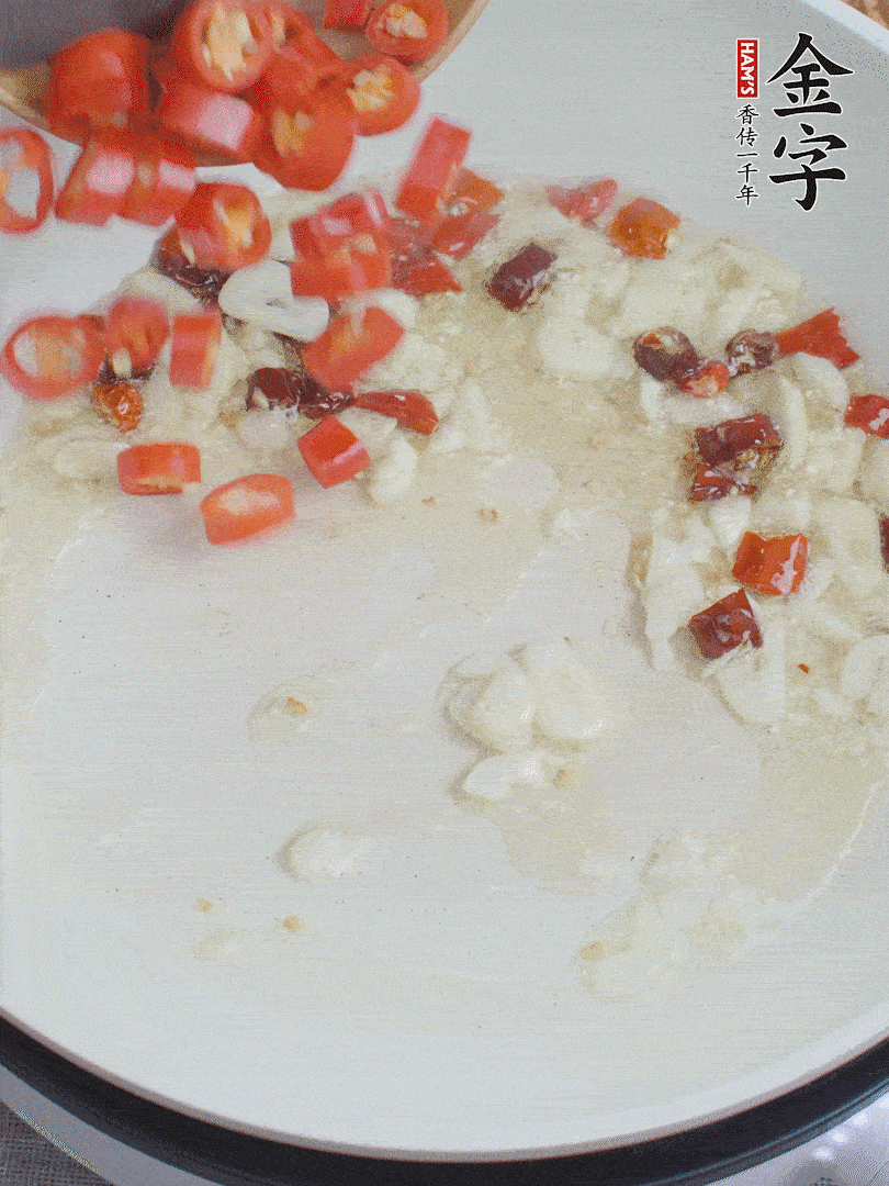 油6成熱，下蒜末、干紅辣椒煸炒，出香味后再放美人椒、香腸。