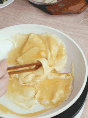 油6成熱時(shí)，下雞蛋液，邊緣凝固時(shí)翻拌成塊狀。