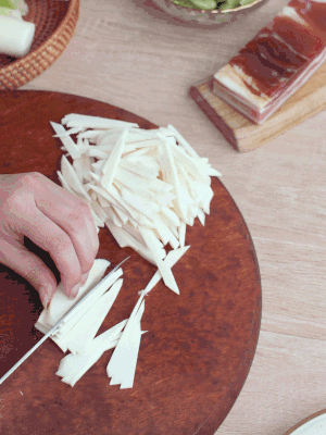 茭白切細(xì)絲，鹽水中浸泡防止氧化。