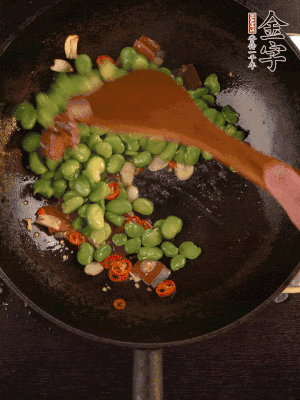 再下蠶豆煸炒，加1勺料酒調(diào)味。