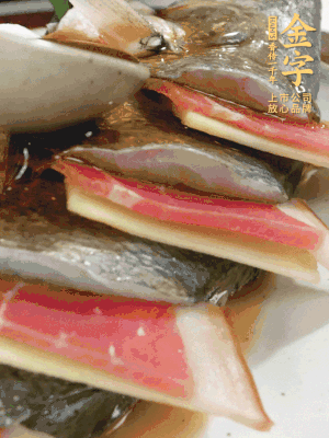 魚肚中塞蔥結(jié)、火腿片，魚身上碼放姜片、火腿片，倒入混合的料汁。