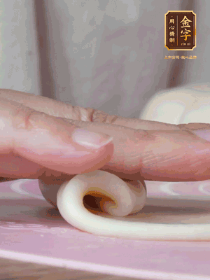 做面劑 油皮按扁，中間包入一個(gè)油酥，邊緣收緊捏死。包好的面劑按扁，用搟面杖搟壓成橢圓形。從底部向上卷成筒狀，用保鮮膜蓋好松弛15分鐘，再把筒狀縱向搟壓成長(zhǎng)條狀。再卷一次，松弛20分鐘