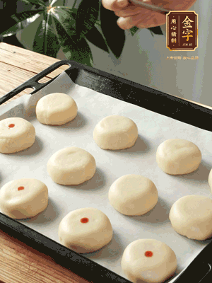 收口向下放在案板上，輕輕將月餅坯按扁，用筷子點(diǎn)紅點(diǎn)做裝飾