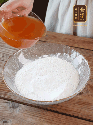 轉(zhuǎn)化糖漿、枧水、花生油攪拌均勻，加入面粉混合，醒發(fā)2小時。捏成23g一個的小球