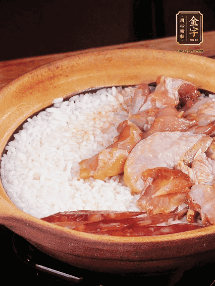 煮到椰子水微微收干轉(zhuǎn)小火，快速均勻鋪上雞肉、金字香腸